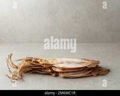 Ein Haufen getrockneter Tintenfische auf Marmorhintergrund Stockfoto