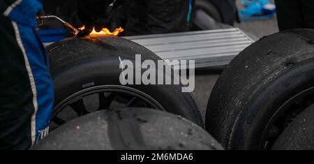 Ein Mitglied der NASCAR-Boxenbesatzung verbrennt und kratzt Gummi von einem Reifen während der Drydene 400 auf dem Dover Motor Speedway in Dover, Delaware, 1. Mai 2022. Der Drydene 400 ist ein Stock Car-Rennen der NASCAR Cup-Serie, das jährlich in der DMS stattfindet. Die Mitglieder der Dover Air Force Base Honor Guard präsentierten die Farben während der Rennen während des gesamten Wochenendes. Dover Air Force Base, Dover Motor Speedway, NASCAR, USAF, Ehrenwache, Stockfoto