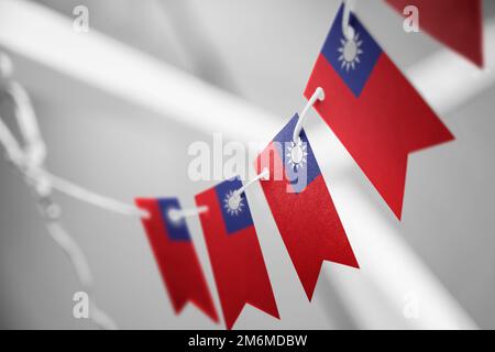 Eine Girlande mit taiwanesischen Nationalflaggen auf abstraktem, verschwommenem Hintergrund. Stockfoto