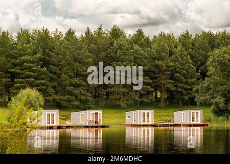 Vier schwimmende Hütten mit schöner Reflexion auf dem See Stockfoto