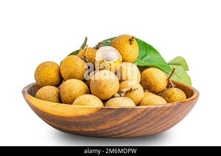 Ein Haufen frischer, ganzer und halb geschälter Longganfrüchte mit grünem Blatt in einer Holzschüssel isoliert auf weißem Hintergrund. Stockfoto