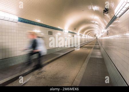 Radfahrer, die durch den alten elbtunnel in hamburg im Untergrund der elbe fahren Stockfoto