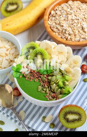 Smoothie-Schüssel zum Frühstück mit Spinat, Banane und Kiwi-Früchten. Stockfoto