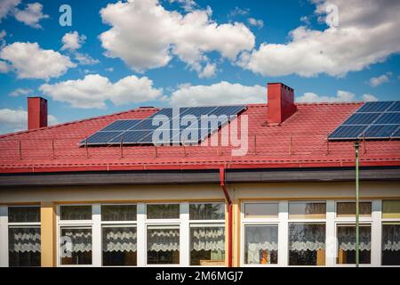 Solarzellenpaneele verwenden erneuerbare Sonnenenergie zur Stromerzeugung, die auf dem Hausdach platziert wird Stockfoto