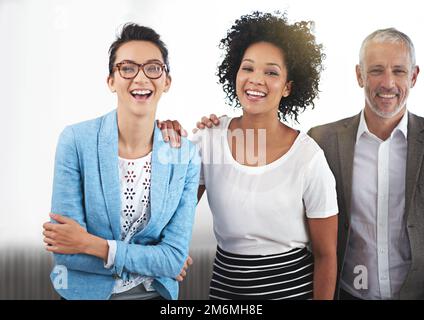 Einen weiteren Erfolg feiern. Porträt einer Gruppe positiver Kollegen, die in einem Büro stehen. Stockfoto