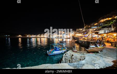 Nachtblick auf die Restaurants im Dorf Matala auf Kreta, Griechenland. Nachtlandschaft aus Lichtern und Tavernen im griechischen Dorf Matala, berühmt für Hippies in der Stockfoto