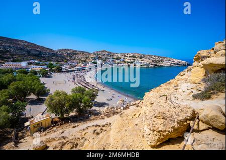 Der berühmte Matala Beach mit seinen Höhlen ist in den 70er Jahren für Hippies bekannt. Blick auf den Strand von Felshöhlen, einst ein römischer Friedhof, am berühmten griechischen Strand Matala, Stockfoto