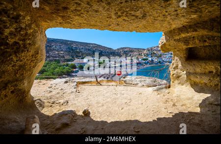 Der berühmte Matala Beach mit seinen Höhlen ist in den 70er Jahren für Hippies bekannt. Blick auf den Strand von Felshöhlen, einst ein römischer Friedhof, am berühmten griechischen Strand Matala, Stockfoto