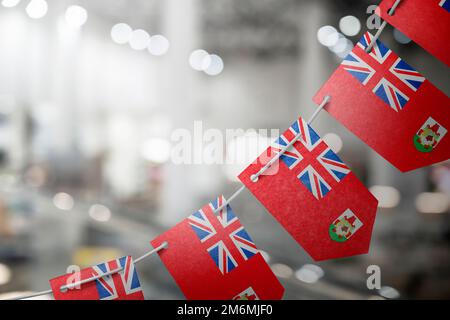 Eine Girlande mit Bermuda-Nationalflaggen auf abstraktem, verschwommenem Hintergrund. Stockfoto