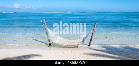 Tropischer Strand mit Hängematte im Meer, weißer Sandstrand mit Hängematte Le Morne Beach Mauritius Stockfoto