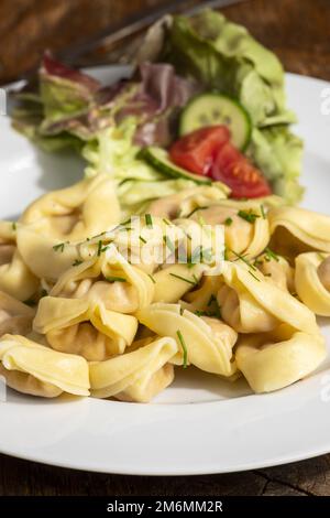 Tortellini-Pasta auf einem weißen Teller Stockfoto