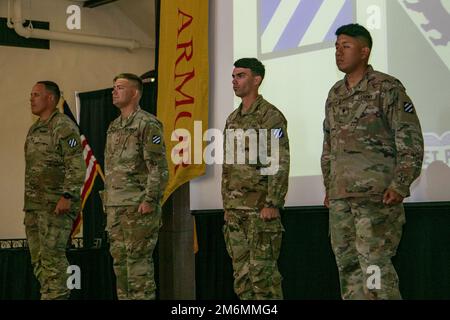 Staff Sgt. Steven Shives, Staff Sgt. Colby Kuberski, Sgt. Grant Arnall und SPC. Alejandro Anguiano, M1A2 Abrams SEP V2 Hauptpanzercrew, 2. Bataillon, 69. Rüstungsregiment, 2. Kampfteam der bewaffneten Brigade, 3. Infanteriedivision, Während der Eröffnungszeremonie in Fort Benning, Georgia, am 2. Mai 2022 präsentieren sie sich als Panzercrew, die den Ausweis für den Sullivan Cup von 3. repräsentiert. Der Wettbewerb konzentriert sich in erster Linie auf die Leistung der Soldaten, die als Besatzung arbeiten. Stockfoto