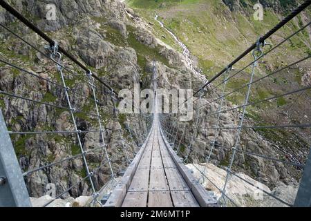 Trift-Hängebrücke in der Nähe des Trift-Gletschers in der Schweiz, die längste Fußgängerbrücke der Alpen, mit einer Gesamtlänge von 170 Metern Stockfoto