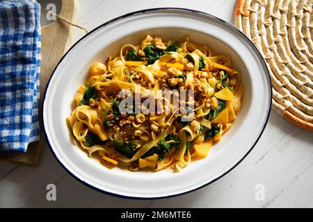 Tagliatelle mit Spinat und Kürbis. Frische italienische Pasta mit Gemüse. Stockfoto