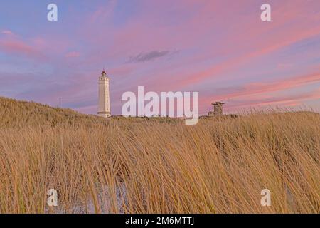 Panoramablick über die Dünen und den Leuchtturm des dänischen Küstenorts Blavand bei Sonnenaufgang an einem eisigen Wintertag Stockfoto