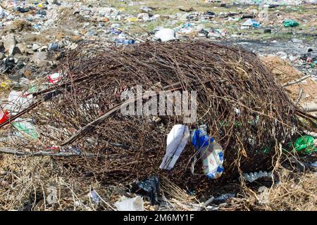 Lagerfoto der verrosteten Drahtrolle auf der Mülldeponie unter Kunststoff- und anderen Abfällen, die von der Entsorgungsfirma gesammelt und dort recycelt werden kann Stockfoto