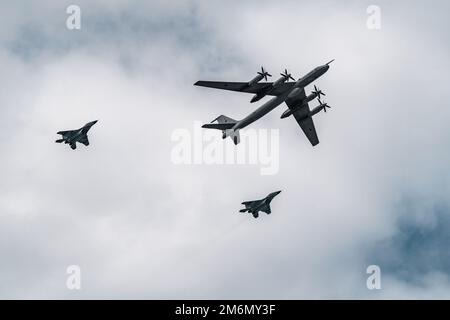 Russland, St. Petersburg, 28. Juli 2022: Militärflugzeuge und Hubschrauber der Luftwaffe fliegen auf der Feier von t in die Stadt Stockfoto