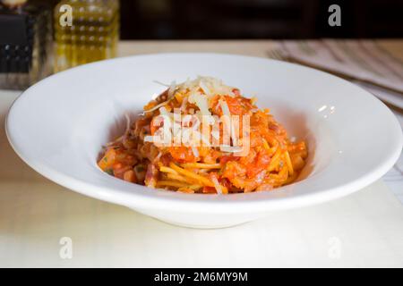 Spaghetti Pasta al pomodoro, zubereitet mit Pasta, Olivenöl, frischen Tomaten, Basilikum und anderen frischen Zutaten. Stockfoto