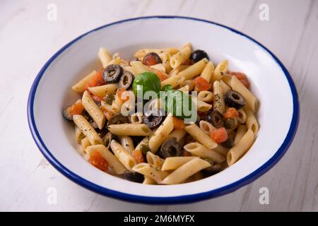 Pasta alla siciliana. Pasta mit Tomatensoße, Basilikum und schwarzen Oliven. Stockfoto