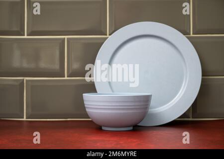 Blaues Verbundmaterial leichtes Camping Geschirr in der Küche auf rotem Linoleum Arbeitsplatte gestapelt Stockfoto