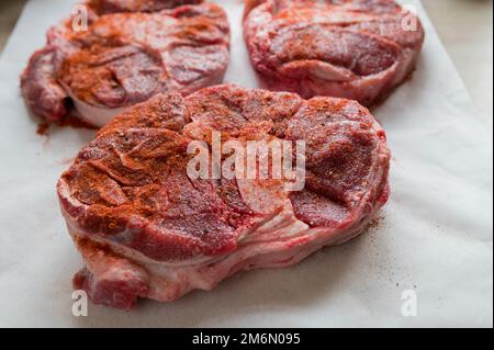 Rinderschaft oder Rinderschenkel roh und nicht gekocht mit Gewürzen. Nahaufnahme und Vorderansicht Stockfoto