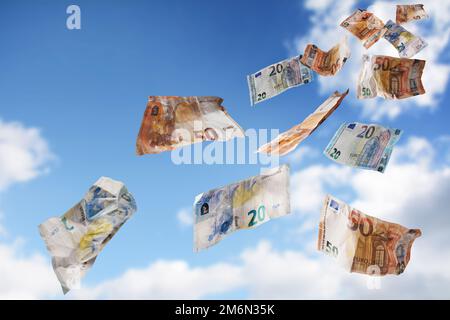 Fliegendes Geld vom blauen Himmel, zwanzig und fünfzig Papierbanknoten in Euro-Währung, Konzept für Finanzen, Geschäftserfolg, Investition oder Lo Stockfoto