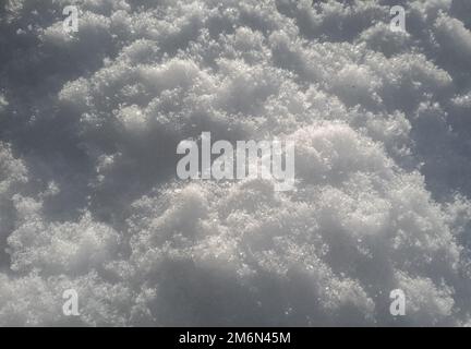 Ansicht der Schneetextur aus einem großen Winkel. Weiße, saubere, glänzende Schneehintergrundstruktur. Nahtlose Struktur für frischen Schnee. Verschneite Nahaufnahme Stockfoto