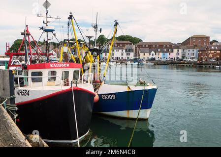 Weymouth Harbour, Dorset, Vereinigtes Königreich: Ein geschäftiger kleiner Hafen, in dem kommerzielle Fischereifahrzeuge am Kai vor Anker liegen Stockfoto