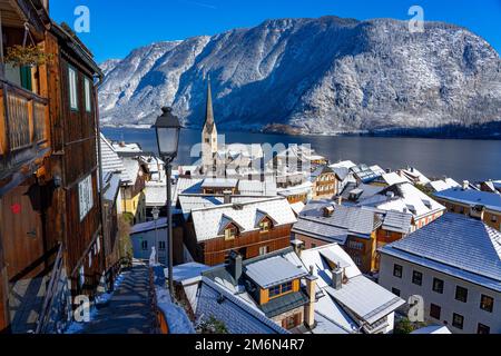 Wunderschönes Stadtbild der besonderen Stadt Hallstatt in Österreich Salzkammergut verschneite Winterberge und See und Kirche. Stockfoto