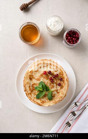 Stapel hausgemachter Pfannkuchen mit Honig und Beeren, Blick von oben Stockfoto