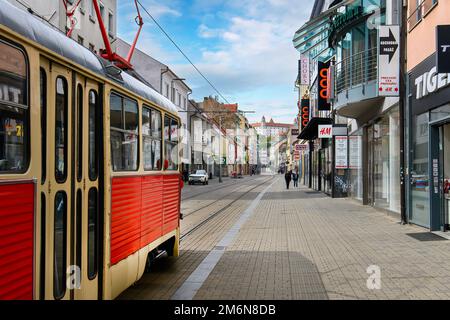 Bratislava, Slowakei. Rote Straßenbahn im Retro-Stil vor dem Schloss Bratislava Stockfoto