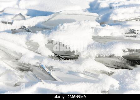 Eisstücke liegen auf dem idealen glatten Eis von baikal mit Eishummocks am Horizont Stockfoto