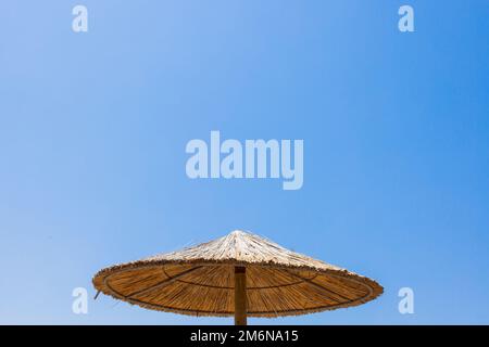 Bambusschirme am Strand mit klarem blauem Hintergrund am Sommertag Stockfoto