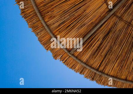 Bambusschirme am Strand mit klarem blauem Hintergrund am Sommertag Stockfoto