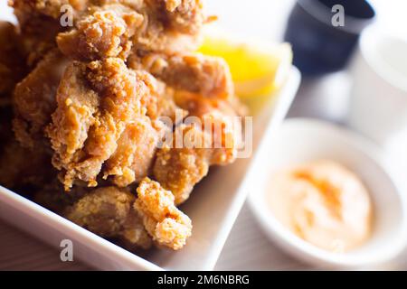 Japanisches Karaage-Hühnchen. Es sind im Grunde mundgerechte Stücke von Hühnerschenkeln, mit Mehl bestrichen und in heißem Öl frittiert. Stockfoto