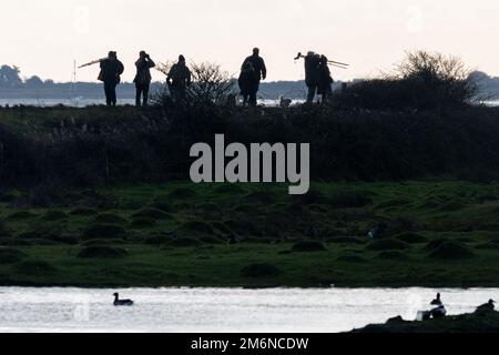 Vogelbeobachter im Farlington Marshes Nature Reserve, Hampshire, England, Großbritannien. Gesunde Outdoor-Aktivitäten oder Hobby. Stockfoto