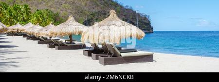 Liegestühle und Sonnenschirme am tropischen Strand von St. lucia, weißer Strand mit Palmen Karibik Stockfoto