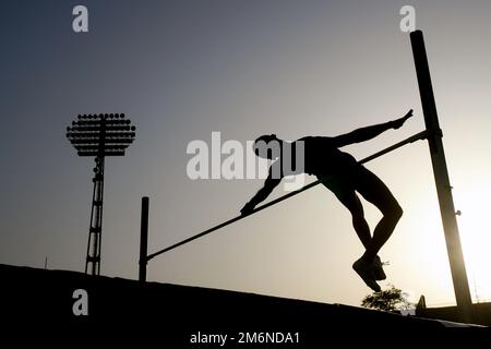 Silhouette eines High-Jumper-Athleten im Stabhochsprung Stockfoto