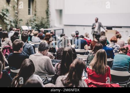 Sprecher männlich, Präsentation im Hörsaal Workshop. Publikum im Saal. Ansicht der Rückseite des Unbekannter Teilnehmer. Wissenschaftliche Konferenzen. Kopieren Sie Speicherplatz auf whitescreen. Stockfoto