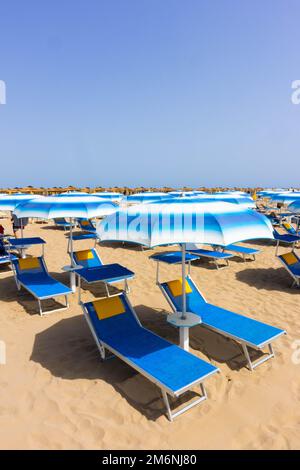Traditionelle Strandliege und Sonnenschirm. Rimini, Italien, Stockfoto