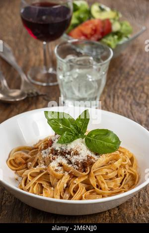 Tagliatelli-Pasta mit Bolognaise-Sauce auf Holz Stockfoto