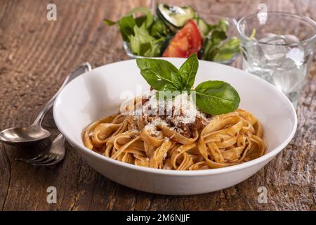 Tagliatelli-Pasta mit Bolognaise-Sauce auf Holz Stockfoto