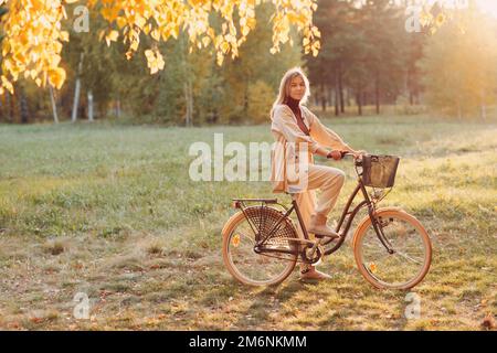 Glücklich aktive junge Frau Fahrrad im Herbst Park reiten Stockfoto