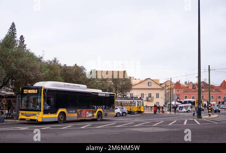 Blick auf einen traditionellen Stadtbus für Passagiere, die durch die zentralen Straßen von Lissabon, Portugal, fahren. Stockfoto