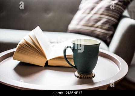 Offenes Buch auf einem Wohnzimmertisch Stockfoto