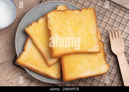 Knusprig getoastetes Brot mit Butter und Zucker Stockfoto