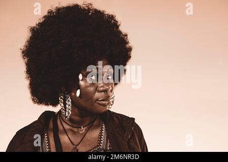 Frau mit großen Haaren und Ohrringen in altmodischem Stil. Stockfoto