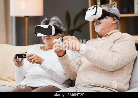 Virtuelle Realität, Gaming und Seniorenpaar auf dem Sofa im Wohnzimmer, die Spaß haben. VR-Gamer, Metaverse und Rentner, ältere Männer und Frauen, die futuristisch spielen Stockfoto