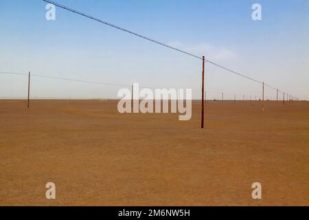 Stromleitungen in der Taklamakan-Wüste. Tarim-Becken. Autonomus-Region Xinjiang (Sinkiang). China. Stockfoto