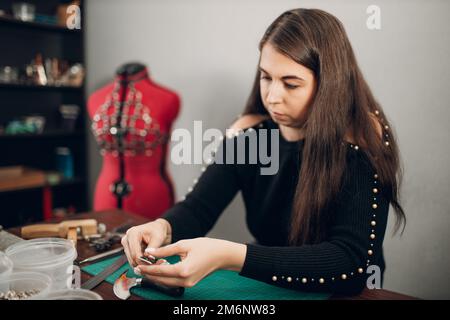 Tanner Frau, die in der Werkstatt Lederwaren anstellt. Arbeitsprozess des Lederhandwerks Stockfoto